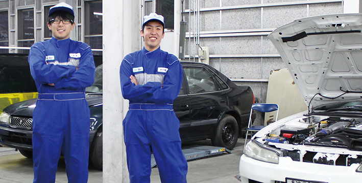 整備車の前に立つ生徒の写真